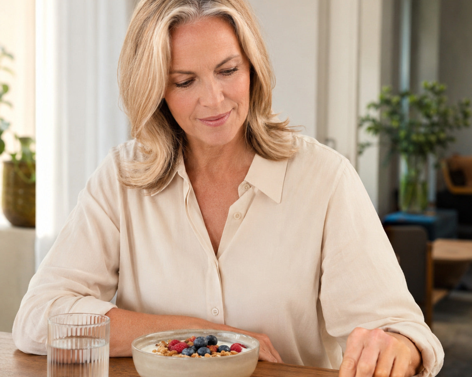 Una mujer combina un desayuno nutritivo con su suplemento nutricional diario